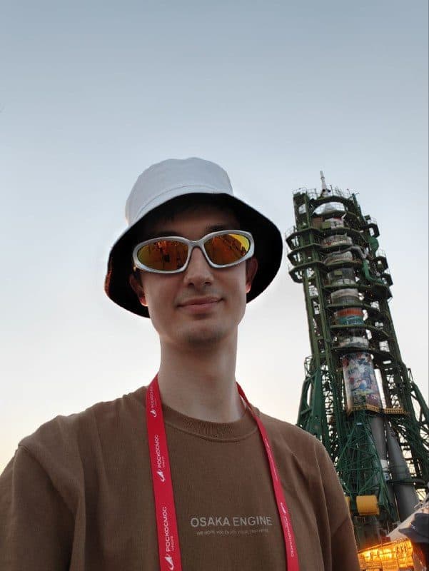 Антон на фоне «Союза-2.1а» на стартовом столе, на корпусе видны детские рисунки