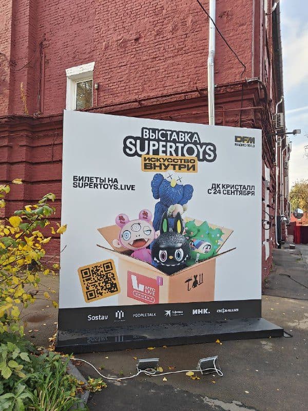 Афиша выставки Super Toys у входа во двор